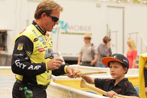 <p>Skeet Reese signs an autograph for a young fan.</p>
