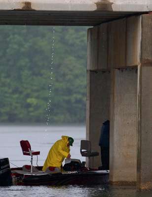 <p>Recreational anglers seek refuge from the rain under a bridge. </p>
