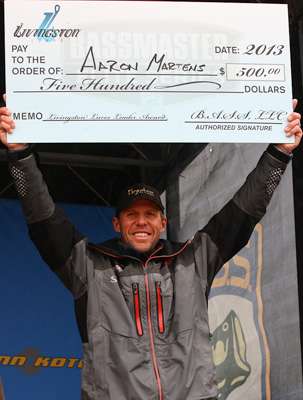 <p>Aaron Martens holds up the bonus check he received from Livingston Lures for leading on Day Two.</p>
