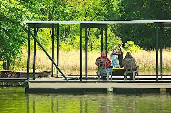 <p>An elderly couple watch Reese from the shade of their dock.</p>
