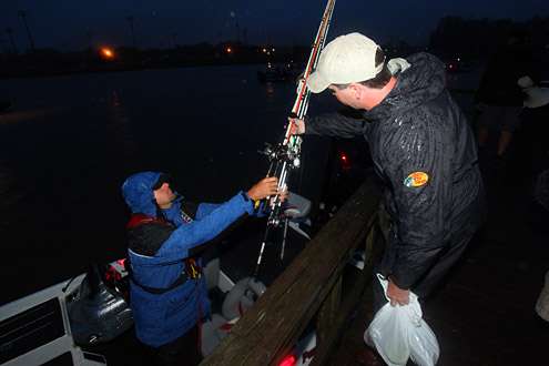 <p> </p>
<p>Chad Thompson hands his gear to Day Three leader David Kilgore before climbing over the dock railing to enter the boat.</p>
