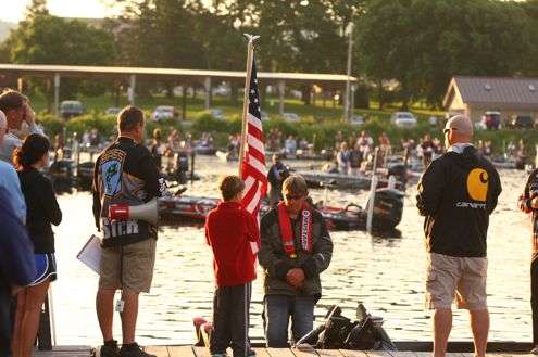 <p>Elite Series tournament personnel and anglers stand at attention for the playing of the National Anthem.</p>

