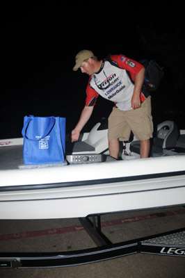 <p>Texan Mike Hughs loads his gear into his boat at the motel.</p>
