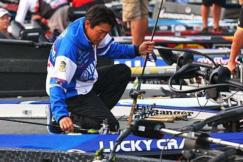 <p>Takahiro Omori gingerly places his rods on the boat deck.</p>
