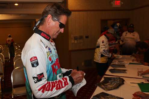 <p>Bernie Schultz takes time out to sign a hat for Eli Delany and his Fishinâ with a Mission project for Autism Awareness.</p>
