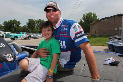 <p>Todd Faircloth awaits his turn on stage as his son jumps up to greet him after his day on the water.</p>
