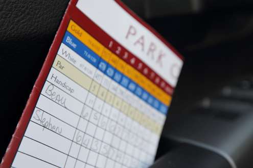 <p>In the door pocket is a scorecard from a recent round of golf. </p>
