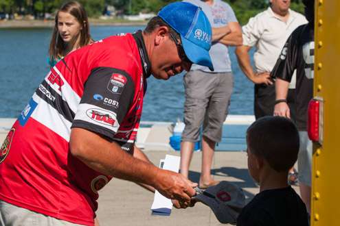 The Classic Champion Cliff Pace takes time to sign a hat for a young angler.