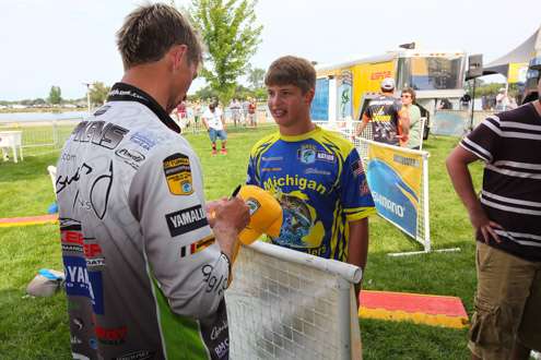 <p>Chad Pipkens signs a hat for one of the young anglers.</p>
