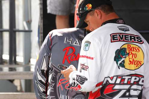 Edwin Evers checks other angler's weights as he waits in a line.