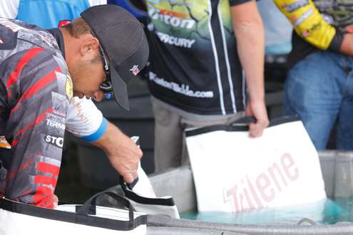 <p>Brandon Palaniuk checks his fish as he waits in the weigh-in line.</p>
