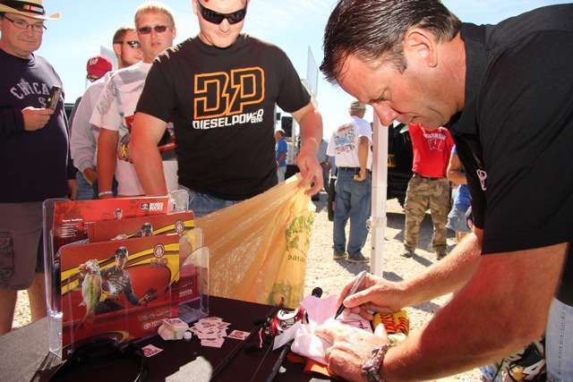 KVD signs an autograph for Garett Guthrie, a race fan from Illinois who loves bass fishing, too.