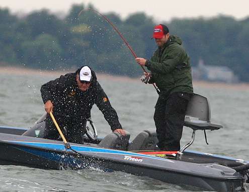 Co-angler Mark Babcock fights a fish to the boat while his Day One pro, Tim Macknair, waits with the net. 