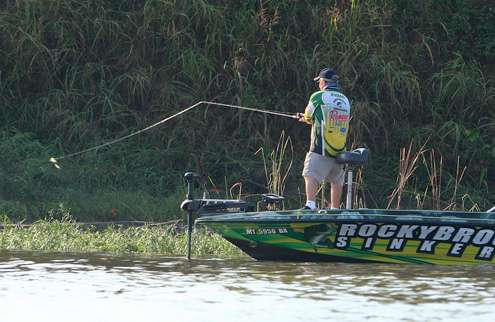 Charlie Evans fires a cast with a spinnerbait along a shallow weed line.