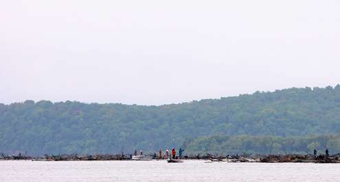 Several anglers crowd into an area near an island. 