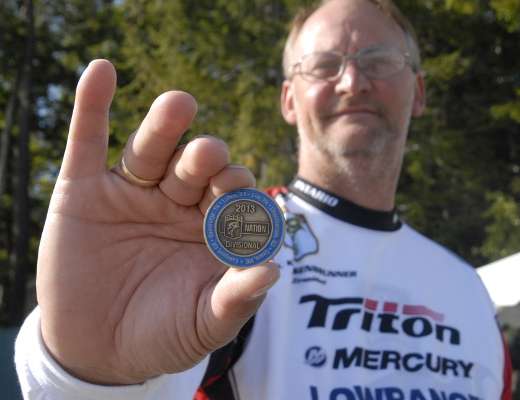 Paul Kroisenbrunner, president of the Ontario B.A.S.S. Nation, displays one of the coins divisional qualifiers receive as part of their gift package.
