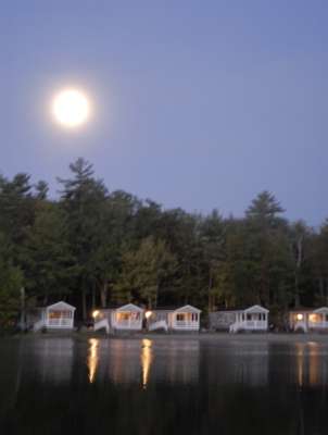 The moon shines bright over the cabins at Point Sebago Resort.