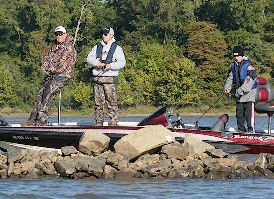 David Wood (boat driver) steers along the jetty while Daryk Eckert and Roman Chapman drag baits around the rocks.
