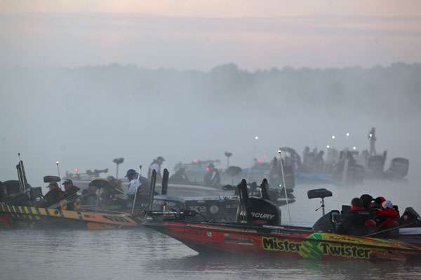 Boats line up in the fog. 
