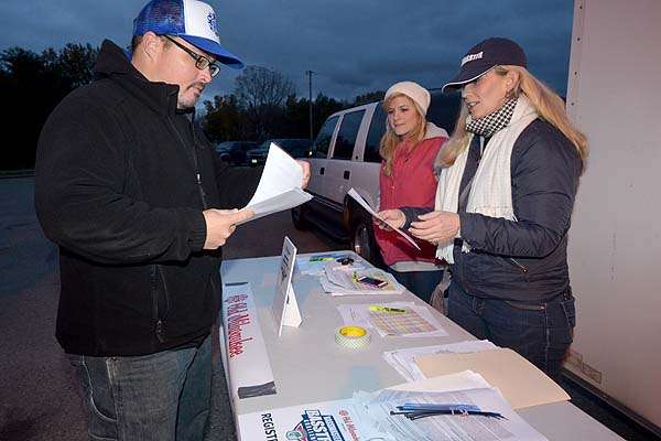 B.A.S.S. staff members Maria Sanders (in red) and April Phillips help Bass Trek anglers sign in Saturday morning.