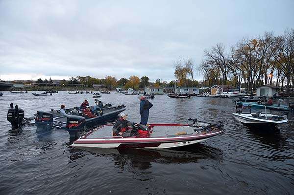 The anglers hustle to their boats and start their engines.