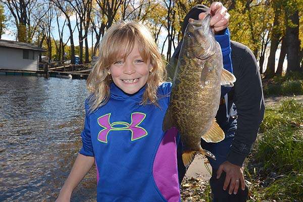 This youngster helped her dad release his bass after the fish had been weighed.