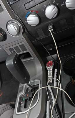 <p>A phone charger and other wires criss cross the dashboard, while extra pens are stored nearby for autograph signing time.</p> 