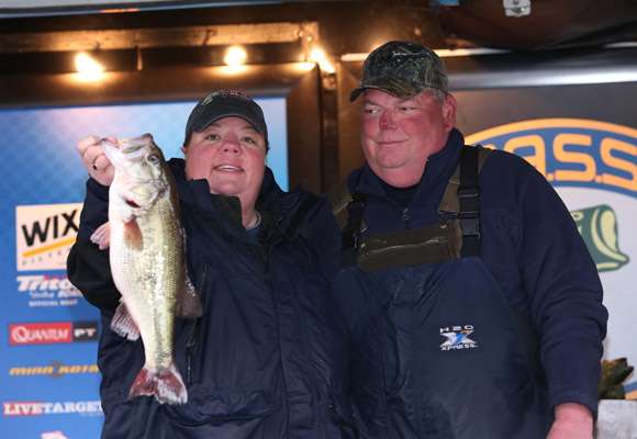 It's weigh-in time, and Angela and John Mayo hold up a nice Norman largemouth.