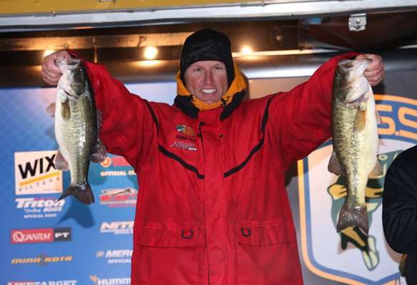 Rich Dunstan holds up two fish for the camera.