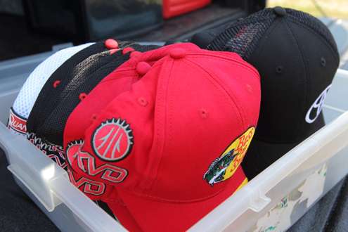 He keeps a supply of hats from his sponsors in back.