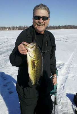 <p>Flanked by snow, Keith Pischke shows off a good-looking bass. This fish came from Webb Lake in Wisconsin.</p>
