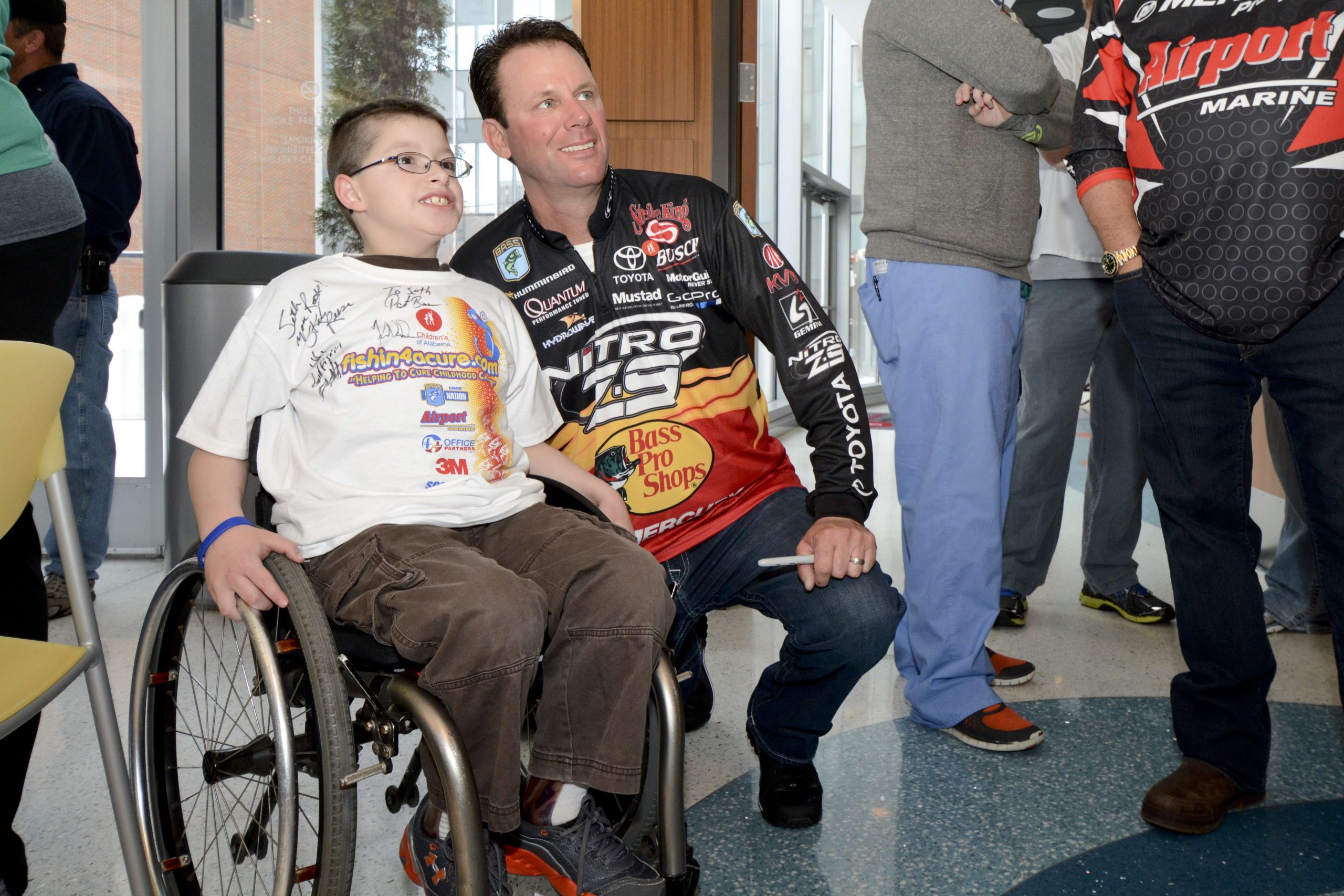 Kevin VanDam takes a photo with a fan in his autographed-filled T-shirt.