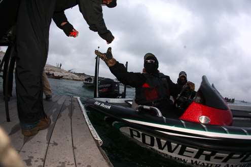 Rick Dusek extends a gloved hand to take his boat number fob at the safety inspection and checkout line. 