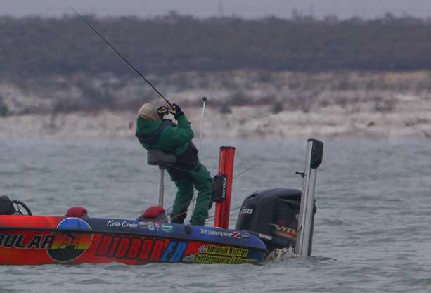 Keith Combsâ co-angler stretches to help fight off the cold morning start on Lake Amistad. 