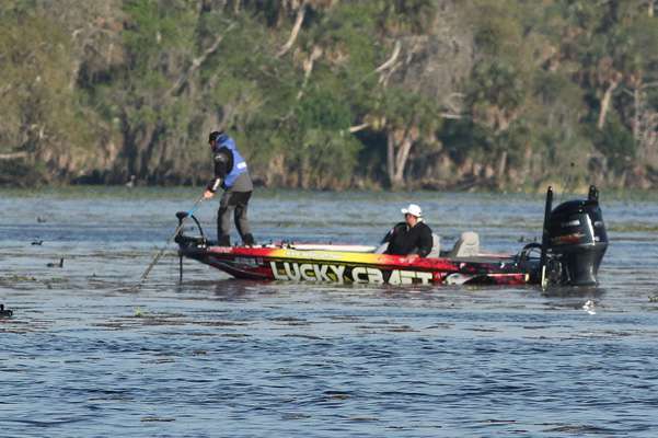 While in the distance, Kelly Jordon pushes his boat into position with a push pole.