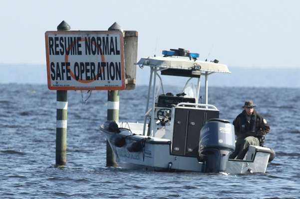 A sign offers advice to boaters while a water patrol officer accentuates the point.