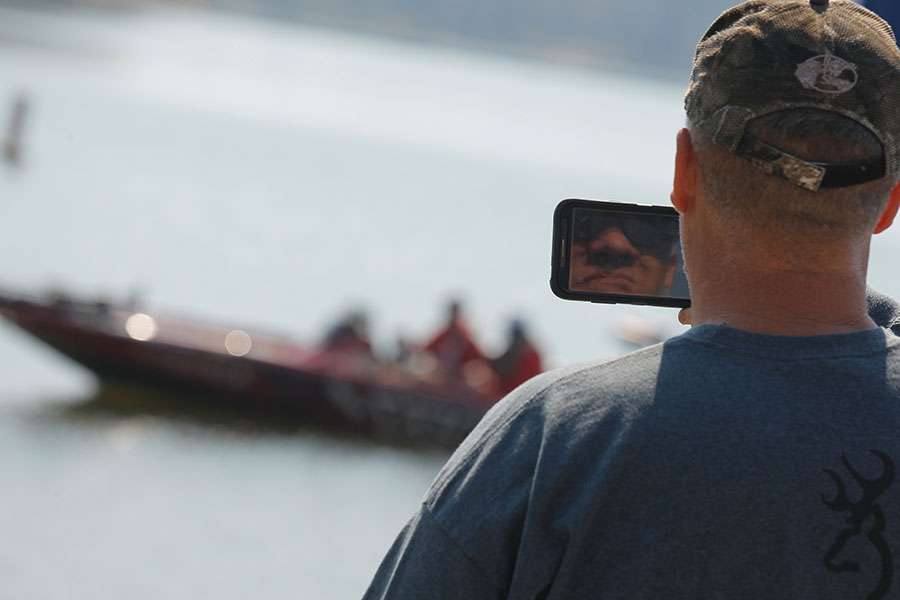 A fan takes video with his smartphone.