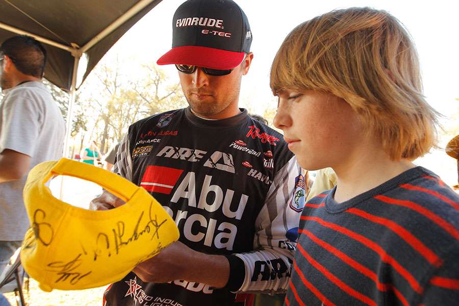Justin Lucas signs his autograph for a volunteer.