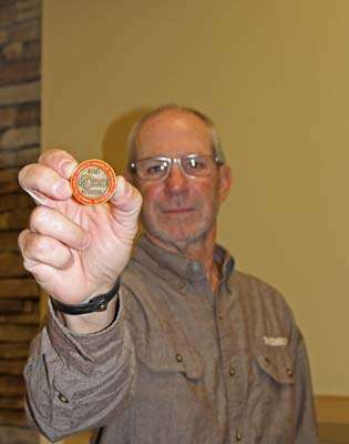 Russ Bradshaw displays the eventâs commemorative coin.