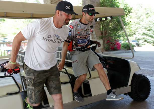 Gerald Swindle and Brandon Palaniuk arrive by golf cart for registration.
