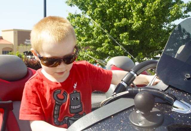 Hunter Pullin, 5, of Rogers was captivated by all the technology found in the driver's seat of Charlie Hartley's boat.