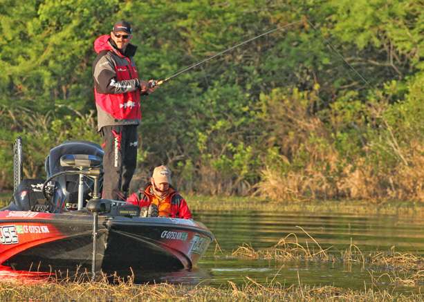 Lintner looks to an area where carp are splashing while spawning.