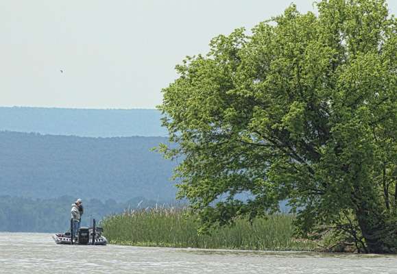 Tommy Biffle fishes with the Ouachita Mountains in the background.