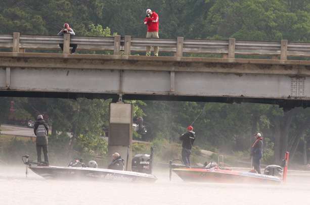 Photographers line up on a bridge to take morning photos of Aaron Martens and Keith Combs. 