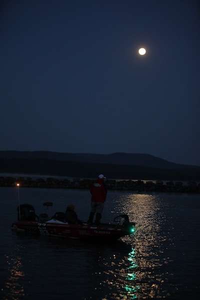 A full moon lights up the night as anglers drop their boats in the water. 