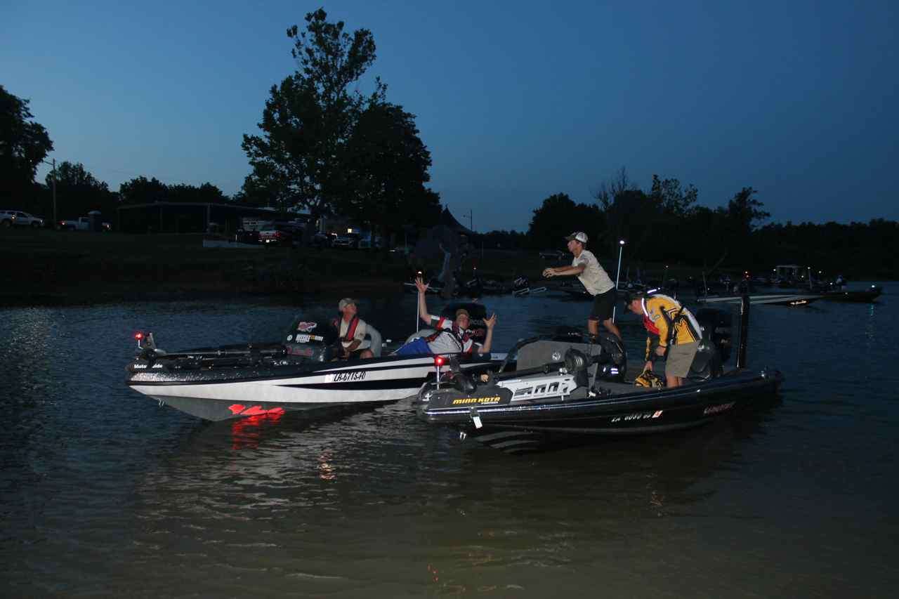 Blake Betz (standing) tosses a PFD over to the boat of fellow Louisiana angler David Cavell, as Nebraska angler Duane Hanzlik gets in position to catch it. Meanwhile, Mississippi angler Savie Goff stows some gear.