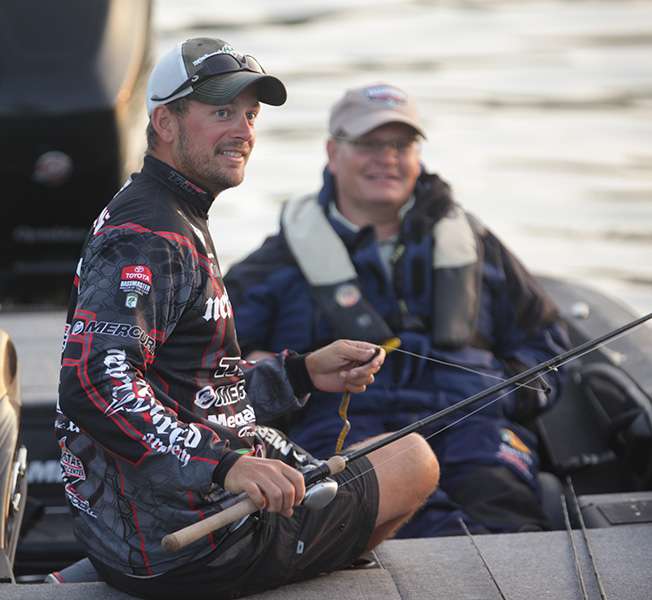 David Mullins converses with other anglers while adjusting his tackle.