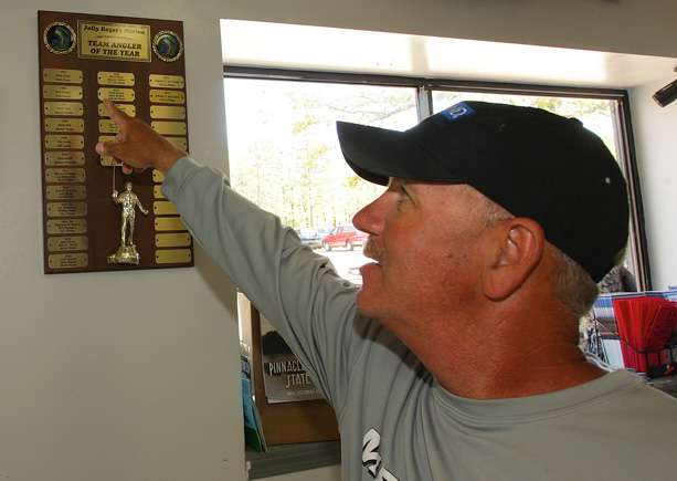 Rook points out some of the names on the list of former top anglers on the lake.
