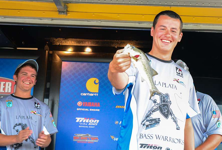 Michael Nutter shows off the smallest fish of the day, 12 ounces. His partner, Evan Charles, laughs in the background