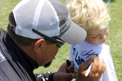 Lane autographs a young angler's t-shirt.